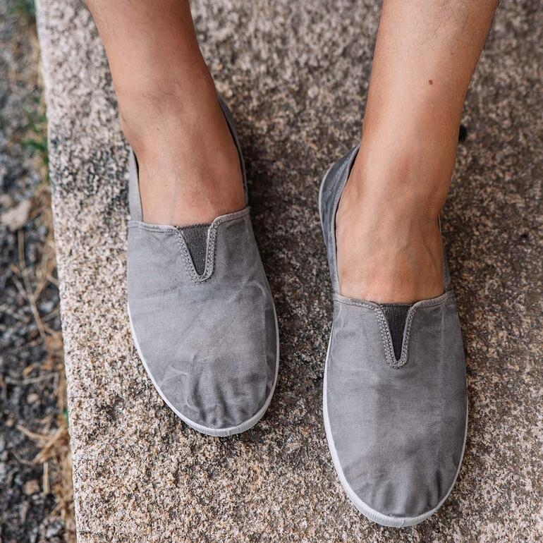 Close-up van een grijze slip-on schoen van bovenaf.