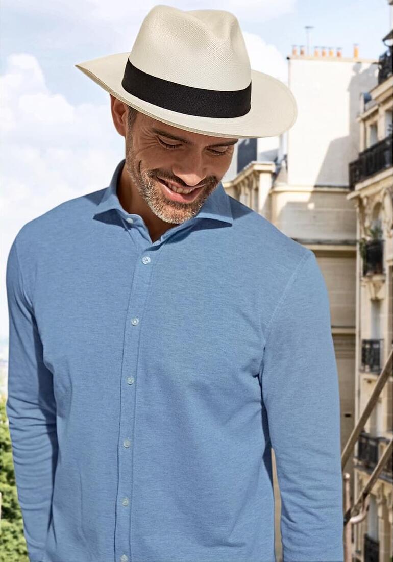 Man met een panamahoed en een lichtblauwe shirt.