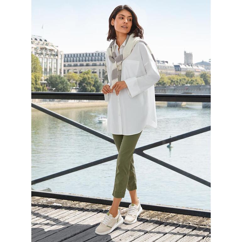 Oversized zomerblouse Vrouw in oversized zomerblouse aan de oever van de rivier.