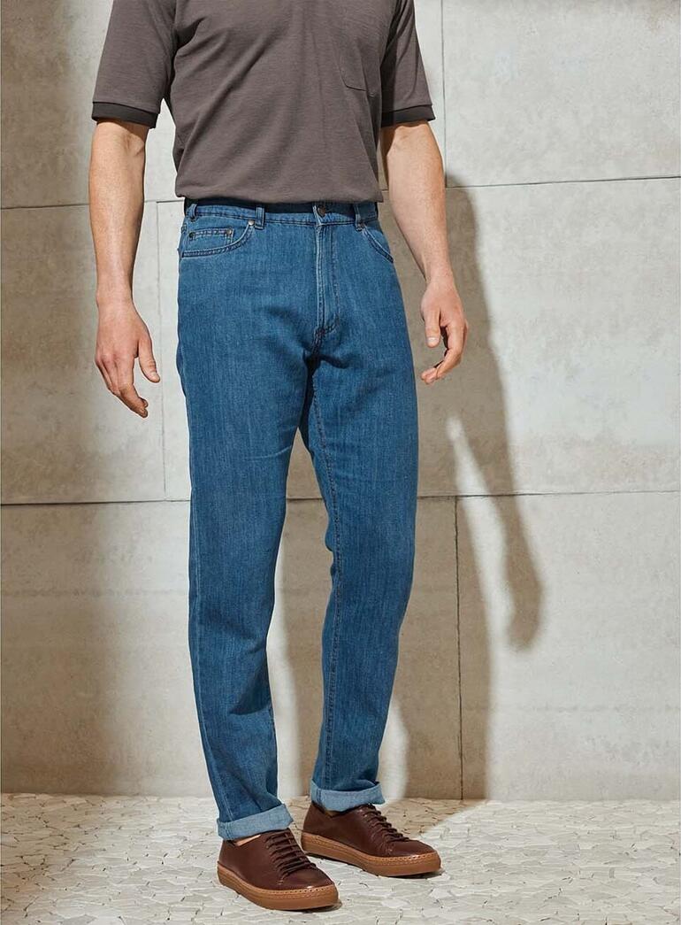 Man in hennepjeans en grijs T-shirt, van voren gezien.