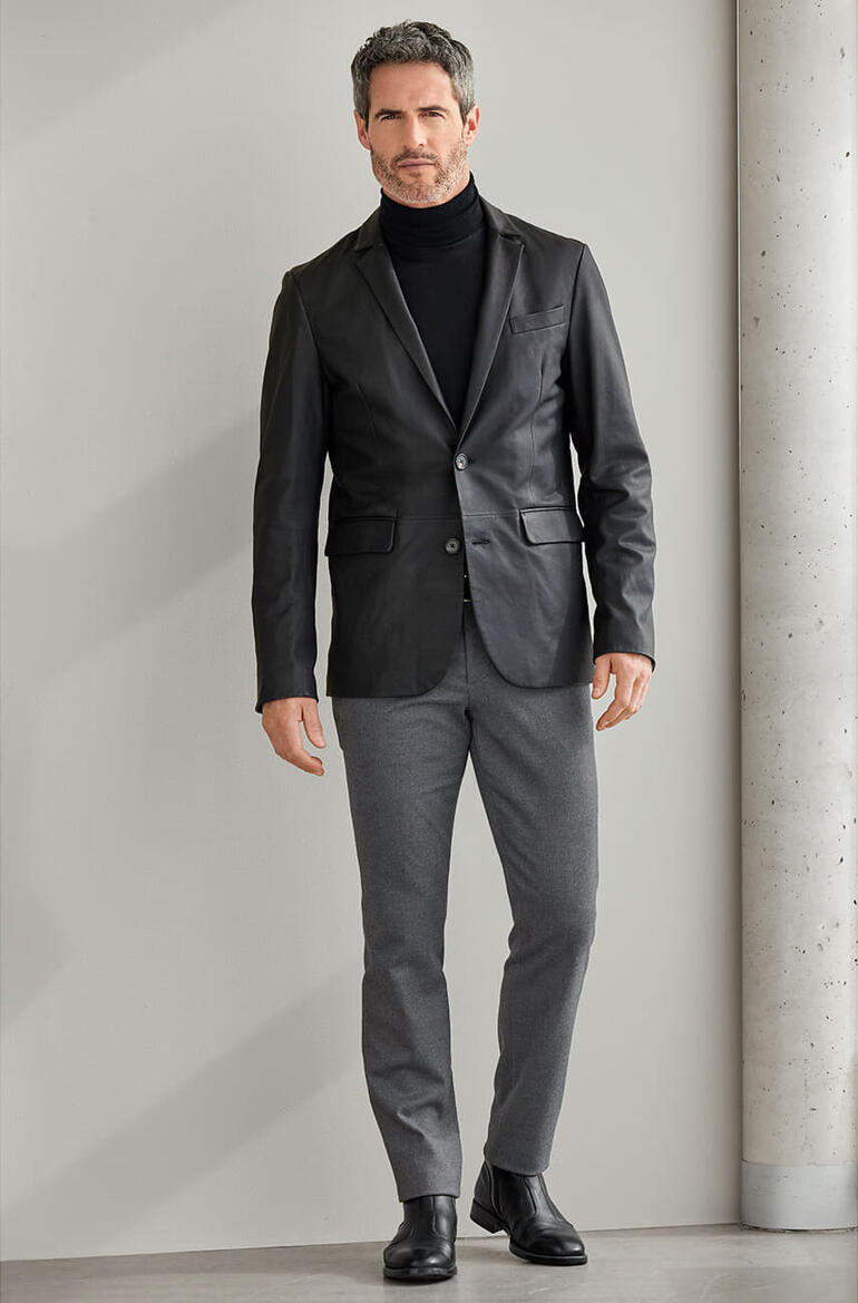 grijs Man in zwart OCONI lamsnap-blazer op een neutrale achtergrond