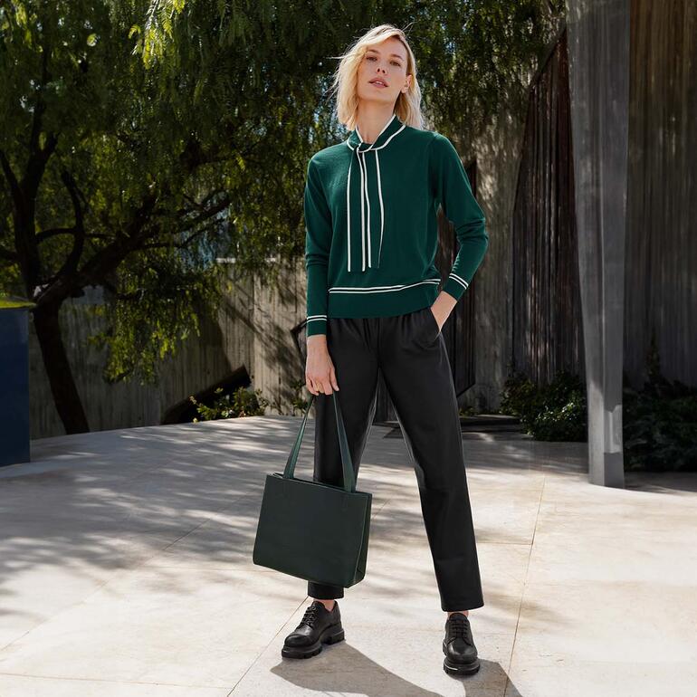 groen/wit Vrouw in groene bindeshirt met zwarte broek.