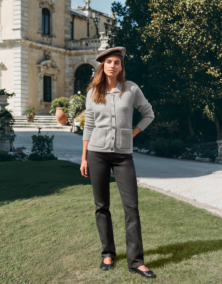 Vrouw draagt grijze Junghans cardigan voor een historisch gebouw