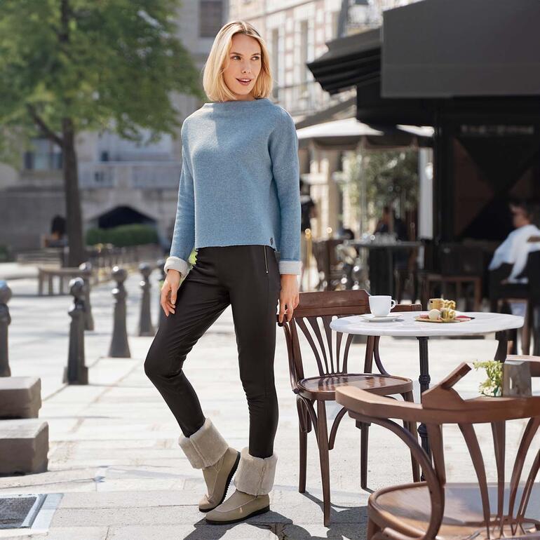 arche boots van doubleface-lamsvacht Vrouw in lichtblauw trui en lamswollen boots zit buiten.