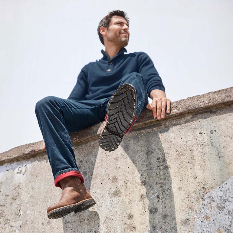 Man op muur in outdoor troye, met een blik naar boven