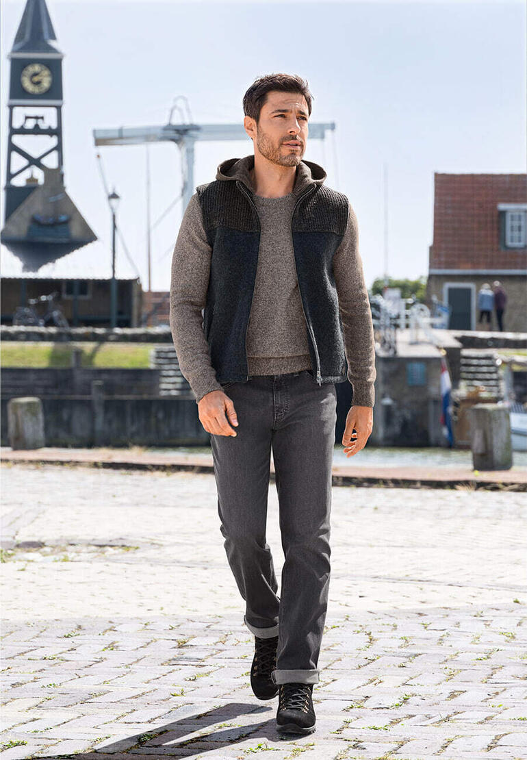 Man in stapf Walk-hoodie vest in een havenlandschap.
