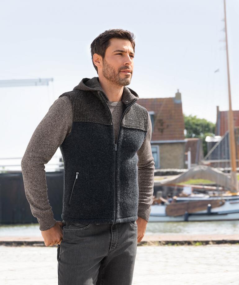 Man in stapf Walk-hoodie vest, kijkend naar de zijkant, haven op de achtergrond.