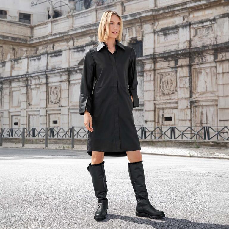 Vrouw in een zwart lamsnappa hemdj dress, staande op straat