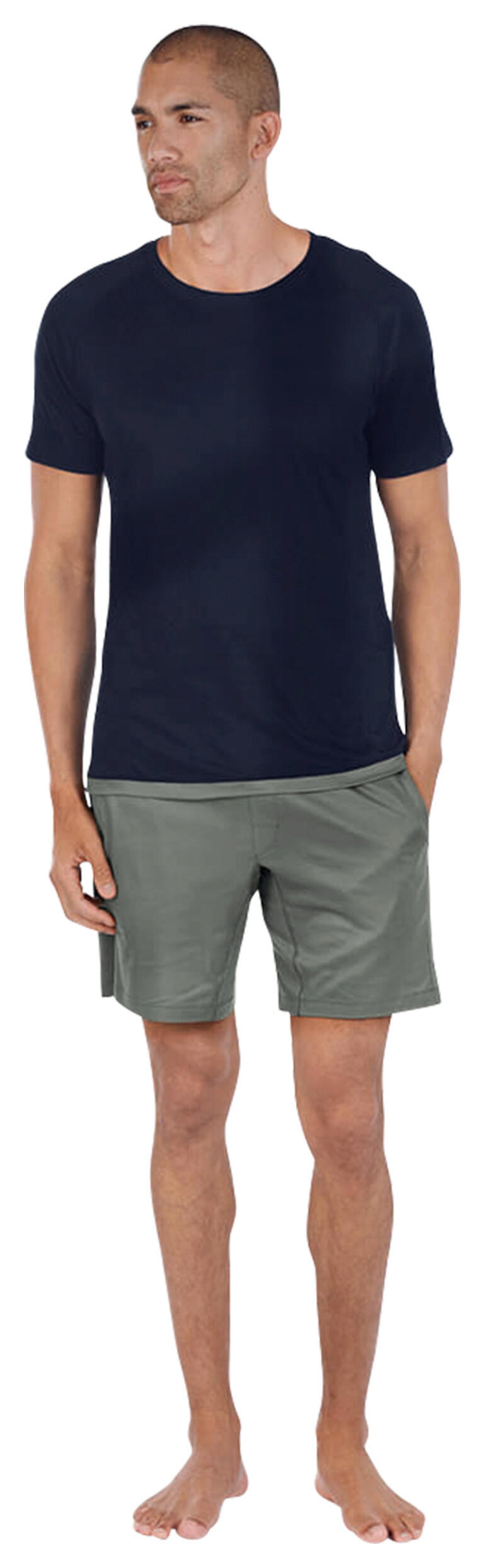 navy/salie Man in donkerblauwe pyjama-top en grijze shorts, staat blootvoets.