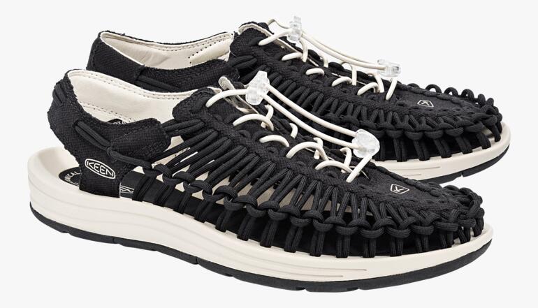 Paar KEEN Outdoor-sandalen Uneek in zwart/wit op een witte achtergrond.