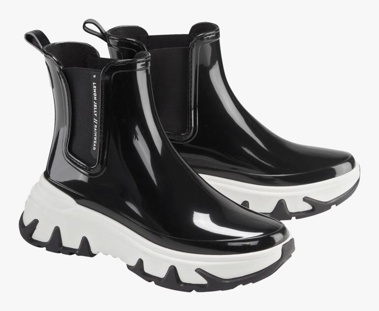 Zwarte Chelsea sneakerboots met witte zolen, paargewijs op een witte achtergrond.