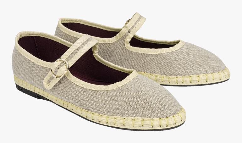 Beige linnen Mary Janes in paar, lichtjes zijwaarts geplaatst.