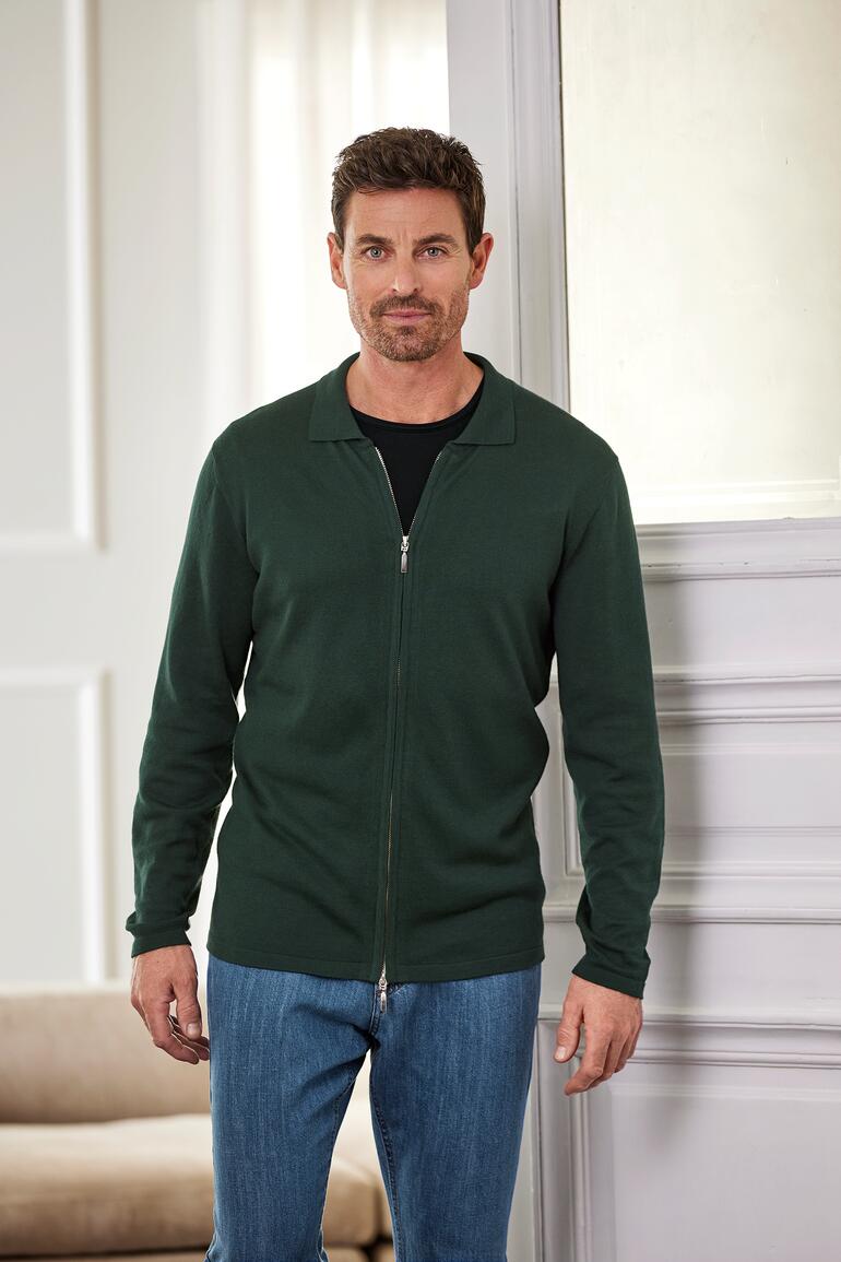 groen Man in een groene jas en zwart T-shirt met een glimlach.