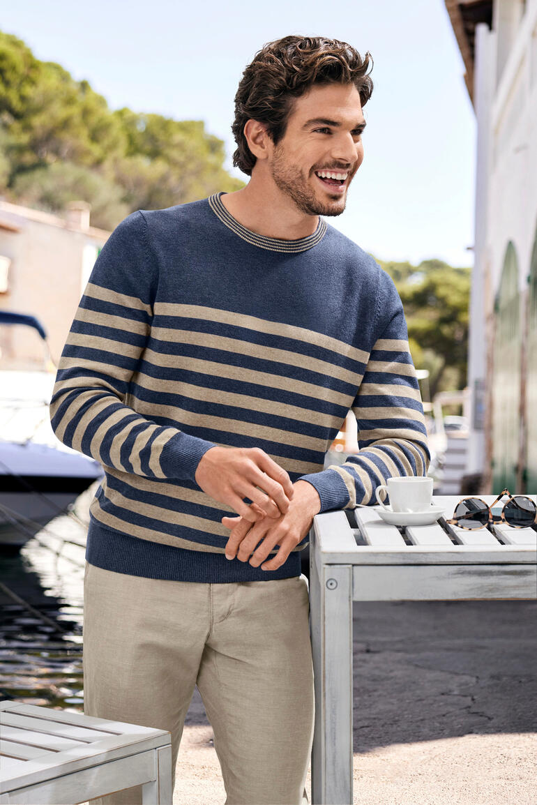 Alan Paine gestreepte hennep-trui Man in gestreept pullover staat bij het water.
