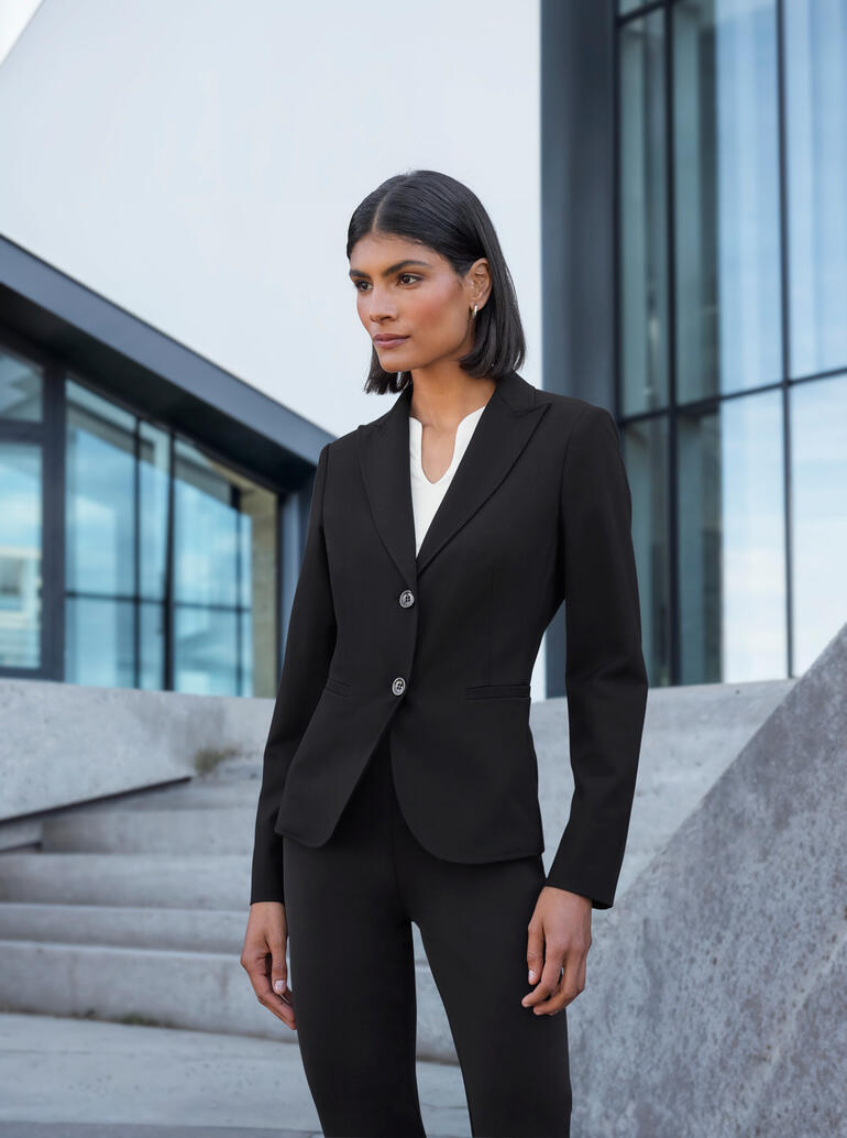 Vrouw in een elegante blazercombinatie voor moderne gebouwen