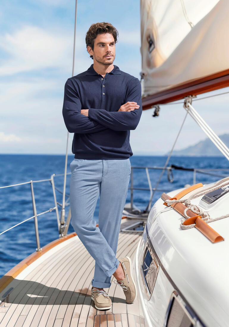 beige Man in een bootsoutfit op een boot met maritieme achtergrond.