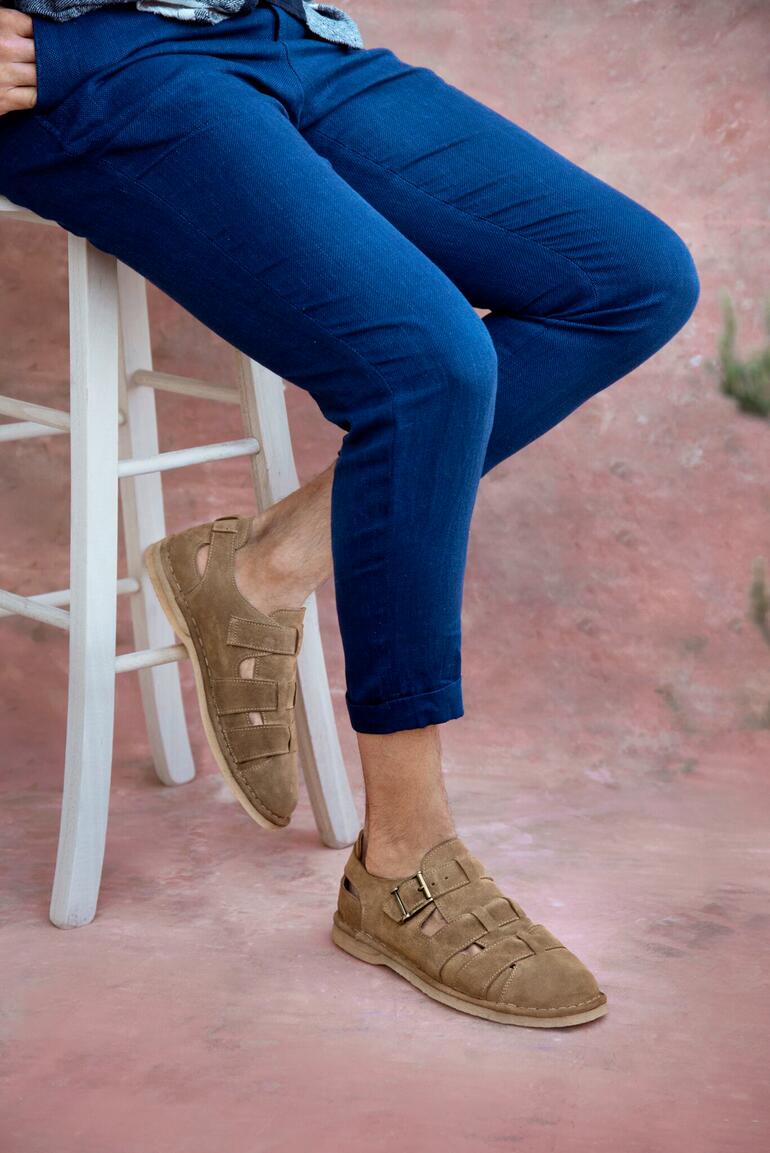 Luxe bakkerssandalen Luxe bakkersandalen in bruin, gecombineerd met blauwe broek.
