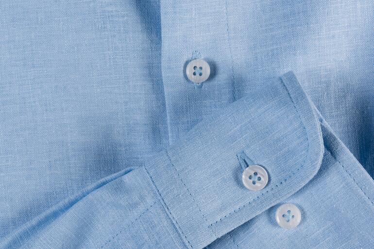 blauw Lichtblauw linnen overhemd met knopen, detailopname.