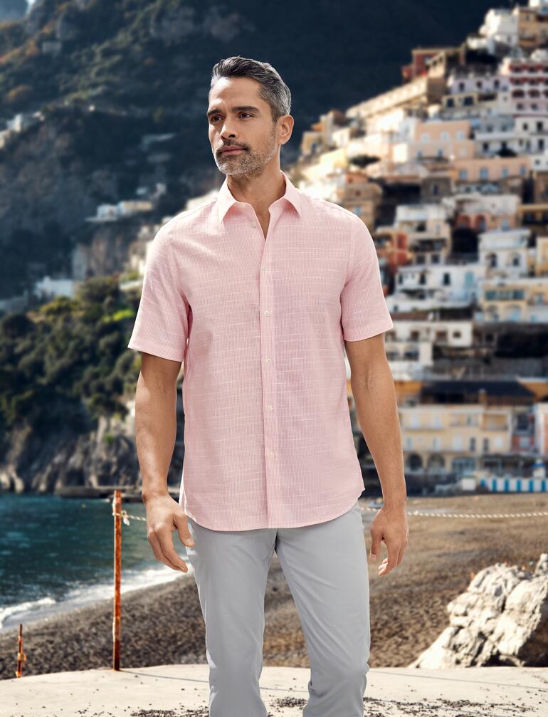 Tropisch overhemd Man draagt een roze tropical overhemd op het strand.