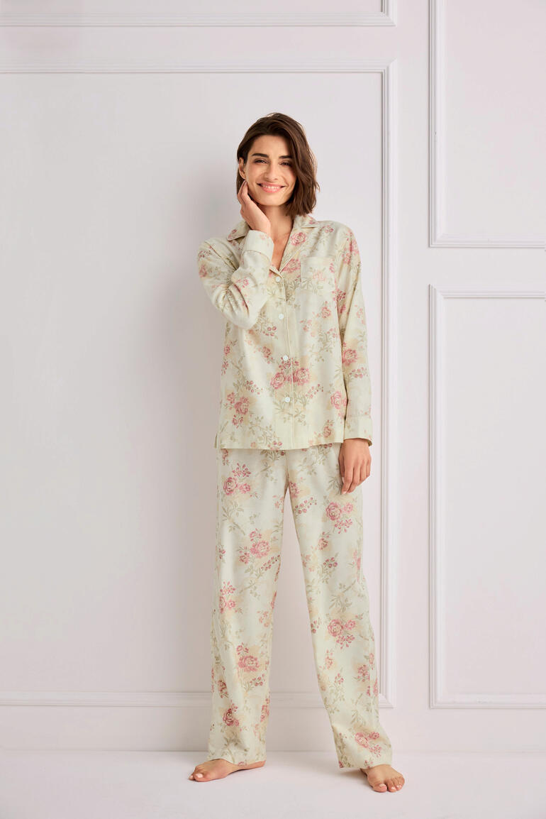 Vrouw in een bloemen Ralph Lauren pyjama staat in een lichte kamer.