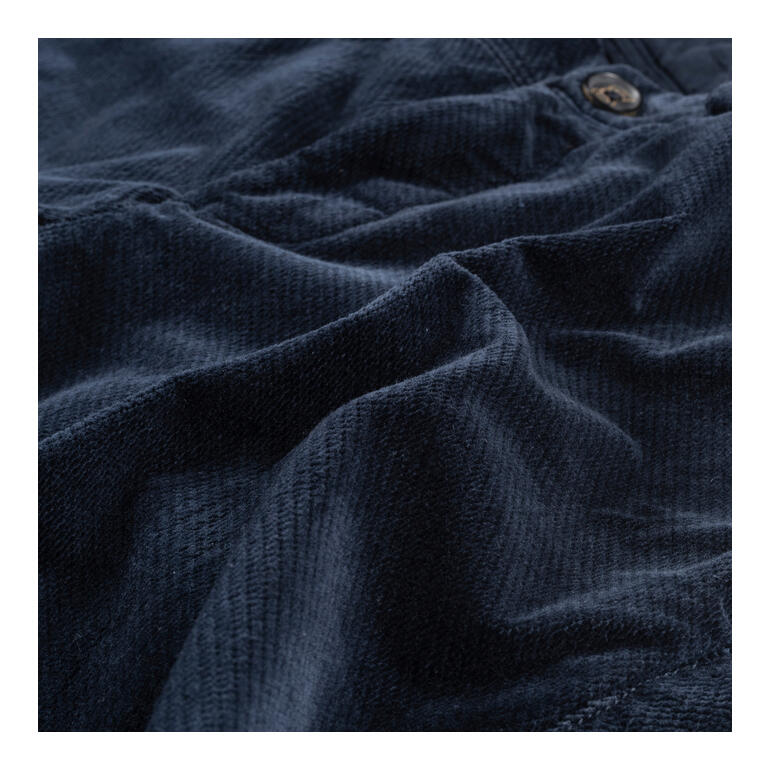 navy Detailopname van een blauwe fluwelen broek met fijne structuur.