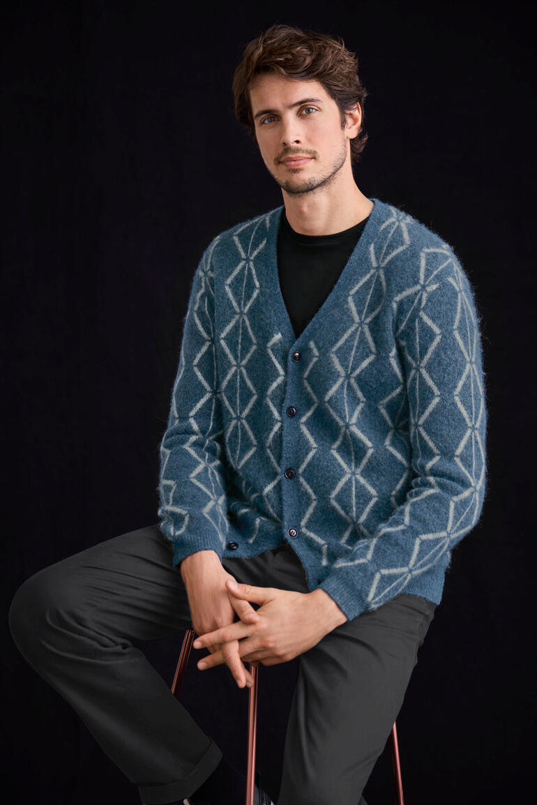 Man zit in een blauwe geborstelde alpaca cardigan met ruitpatroon.