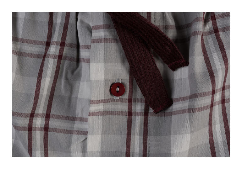 wijnrood/grijs/wit/grijs Close-up van een geruite tailleband met een rode knop.