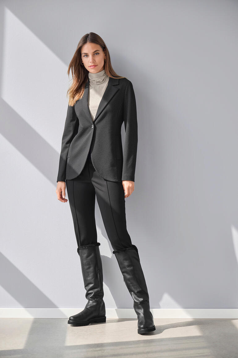 Vicario Cinque jersey blazer met stippen Vicario Cinque jersey stippen colbert, model staat tegen de muur.