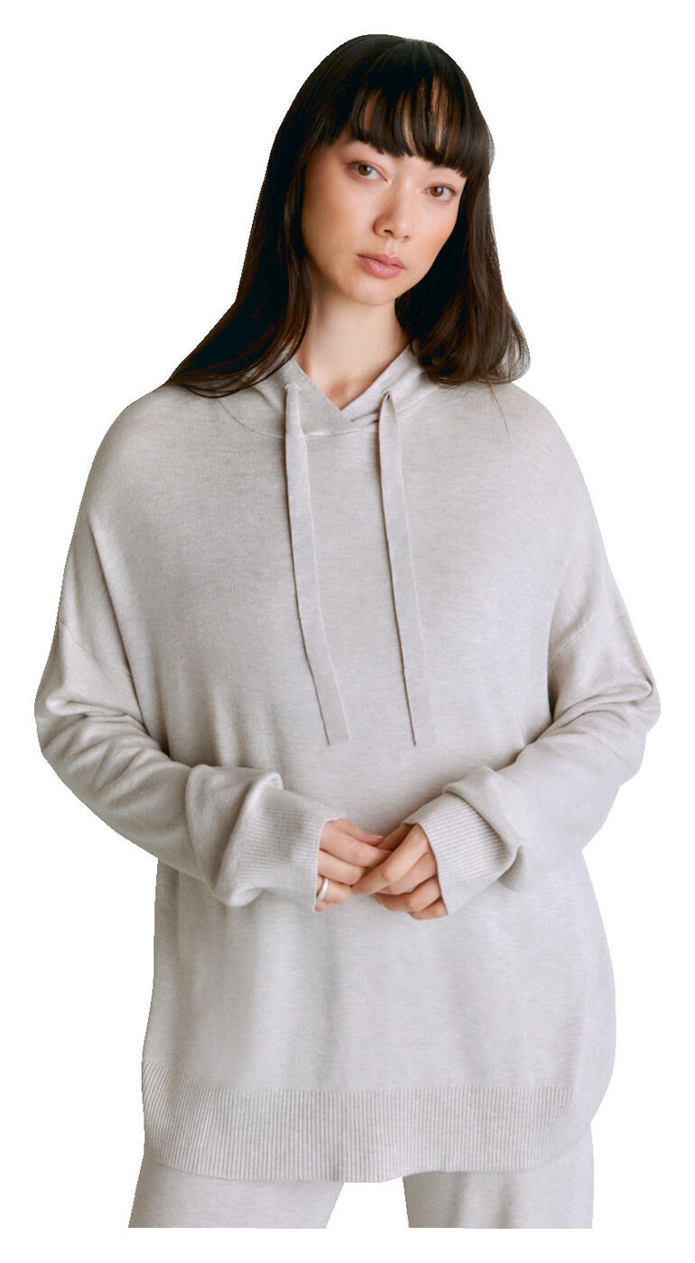 Hoody van lyocell/kasjmier Vrouw in een lichtgrijze lyocell/kasjmier hoodie met capuchon op een witte achtergrond.