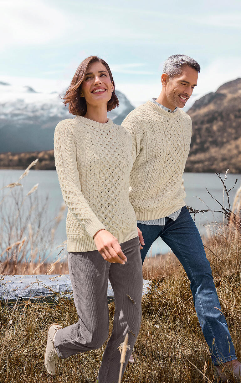 Stel in Merino-Aran truien tijdens een wandeling met natuurlijke achtergrond