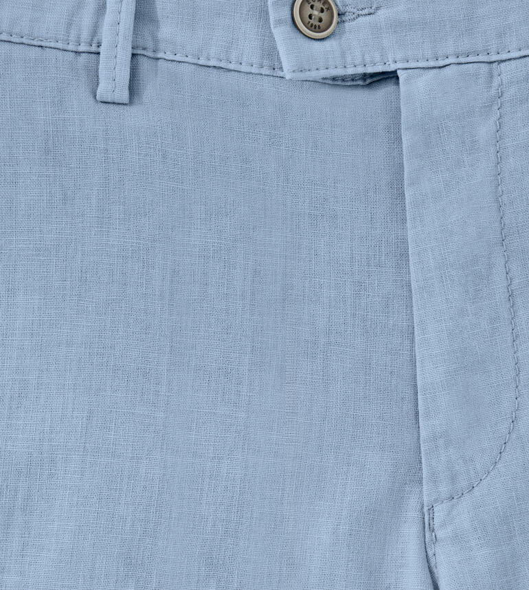 Detailweergave van een lichtblauwe linnen bermuda met knoop en zakken.
