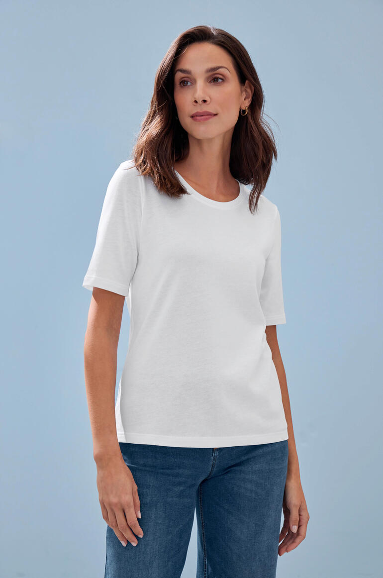 Tencel™ T-shirt Wit Tencel™-T-shirt op een model voor een blauwe muur.