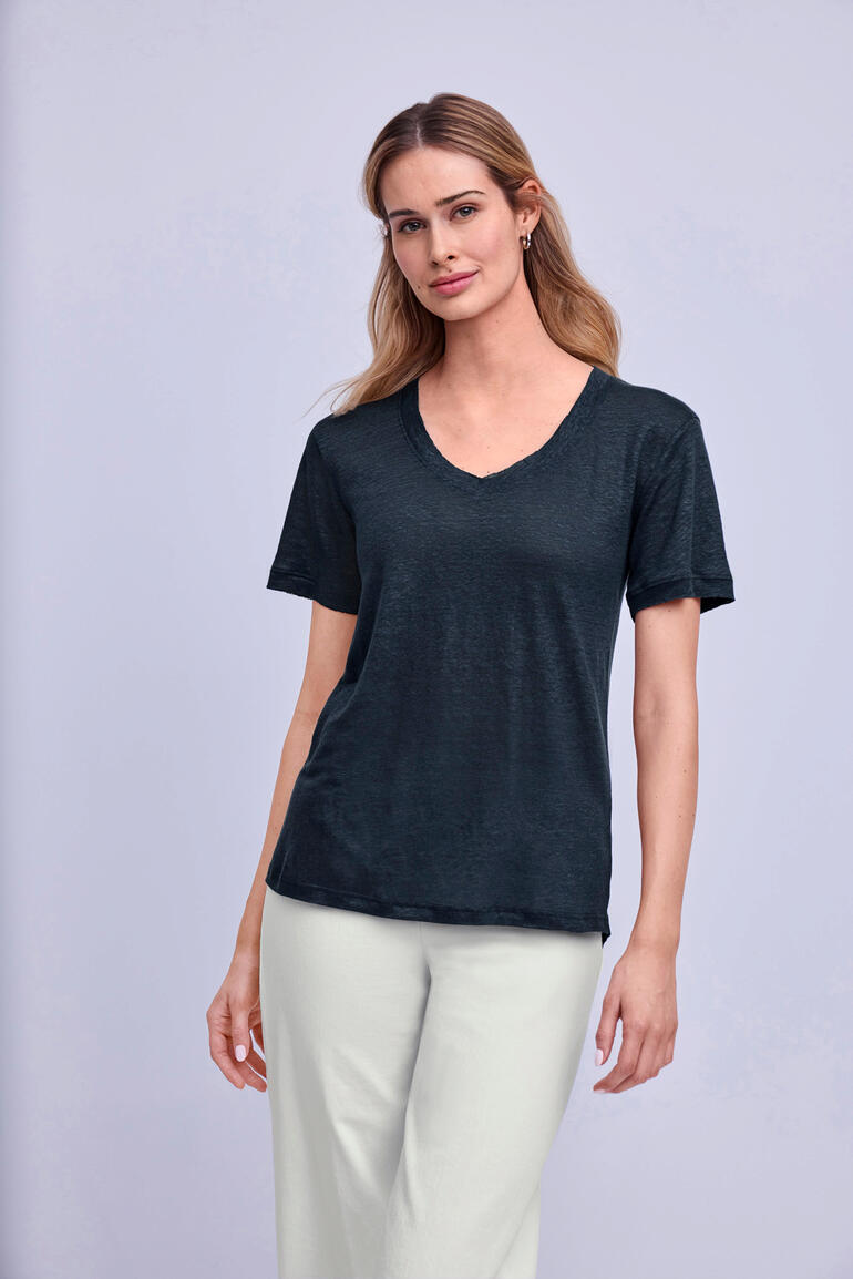 Vrouw draagt een zwarte Edel-Linnen shirt met V-hals.