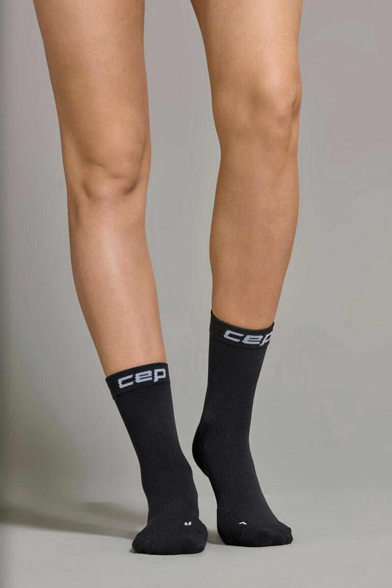 dames, zwart Zwarte Core sportsock, zichtbaar aan een voet, van voren.