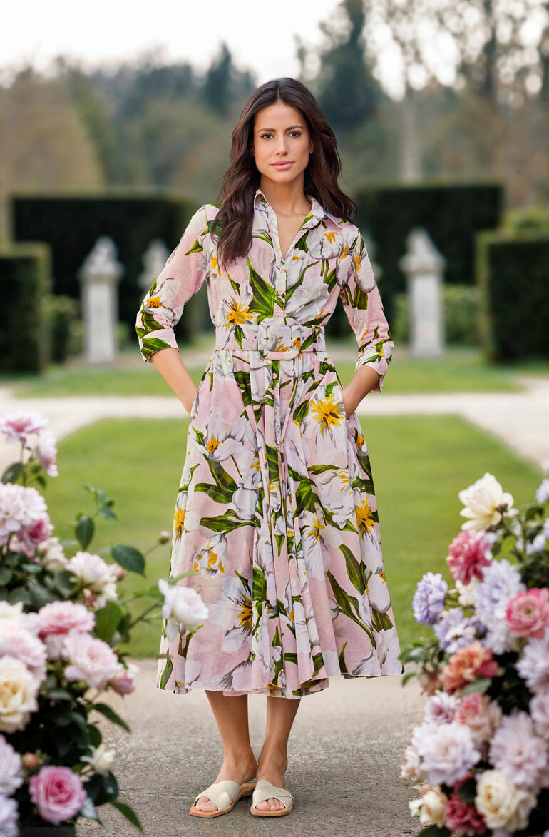 Vrouw in Samantha Sung jurk met bloemenpatroon in een tuin