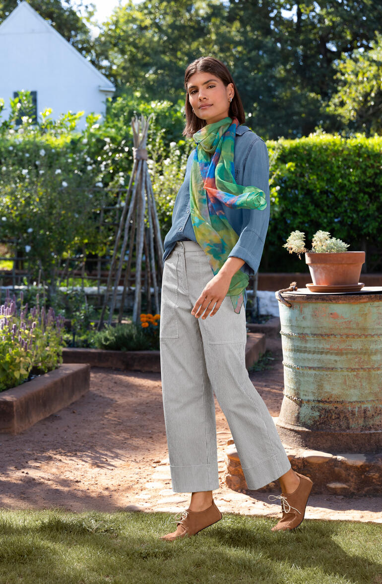 Bella Dahl spijkerblouse Bella Dahl spijkerblouse in blauw, gedragen door een vrouw in een tuin.