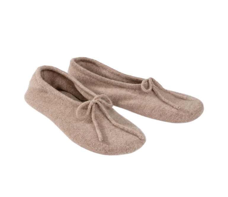 Twee kasjmier reisschoenen in lichtbeige naast elkaar.