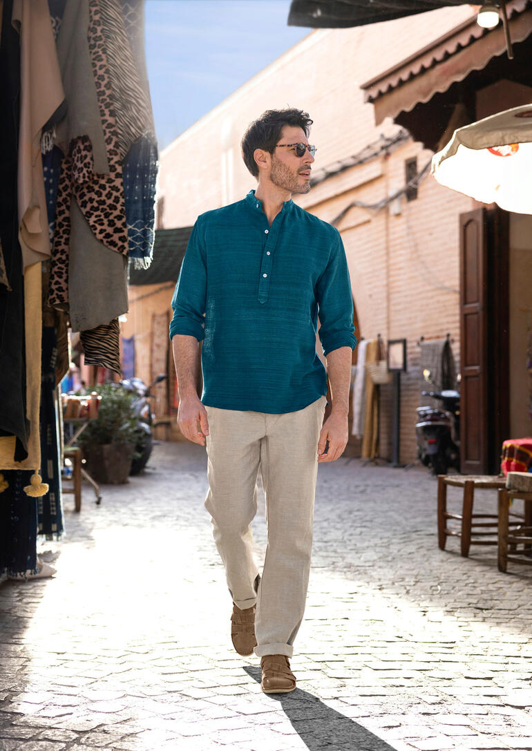 OMTC handgeweven zijden kurta Man draagt handgeweven zijde kurta in een drukke markt met kraampjes.