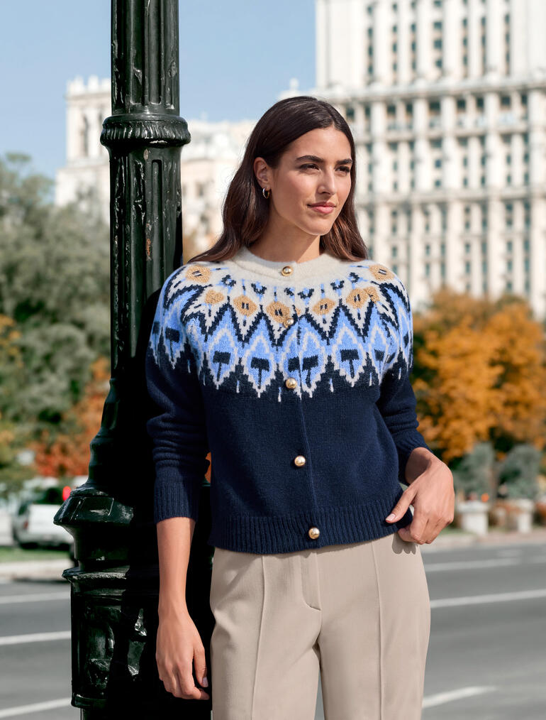 Vrouw draagt een JH1954 couture Noors cardigan met kleurpatronen