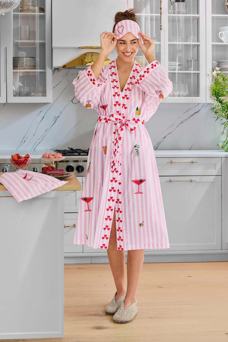 Vrouw in een gestreepte pyjama met hoed in een moderne keuken.