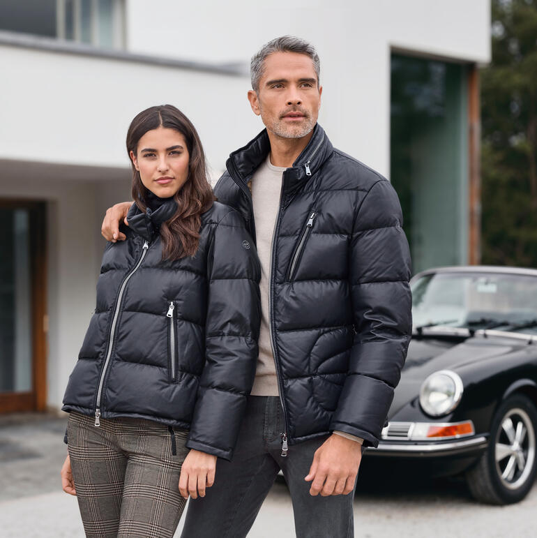 Man en vrouw in zwarte donsjassen, lachend.