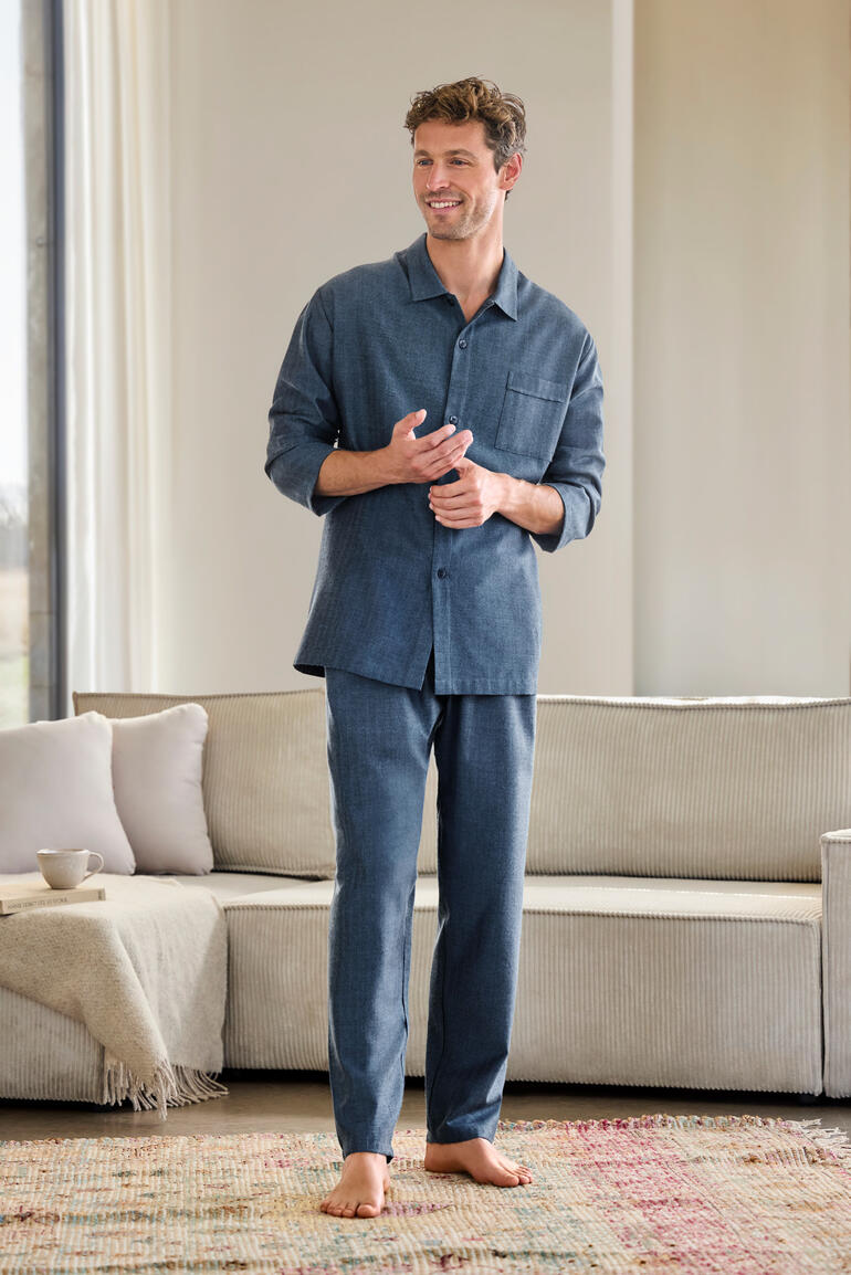 Man draagt een flanellen visgraat pyjama in donkerblauw met een borstzak.