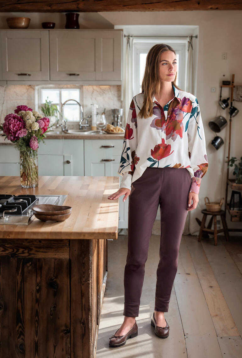 Vrouw in een Flower-Flanellblouse staat in een moderne keuken.