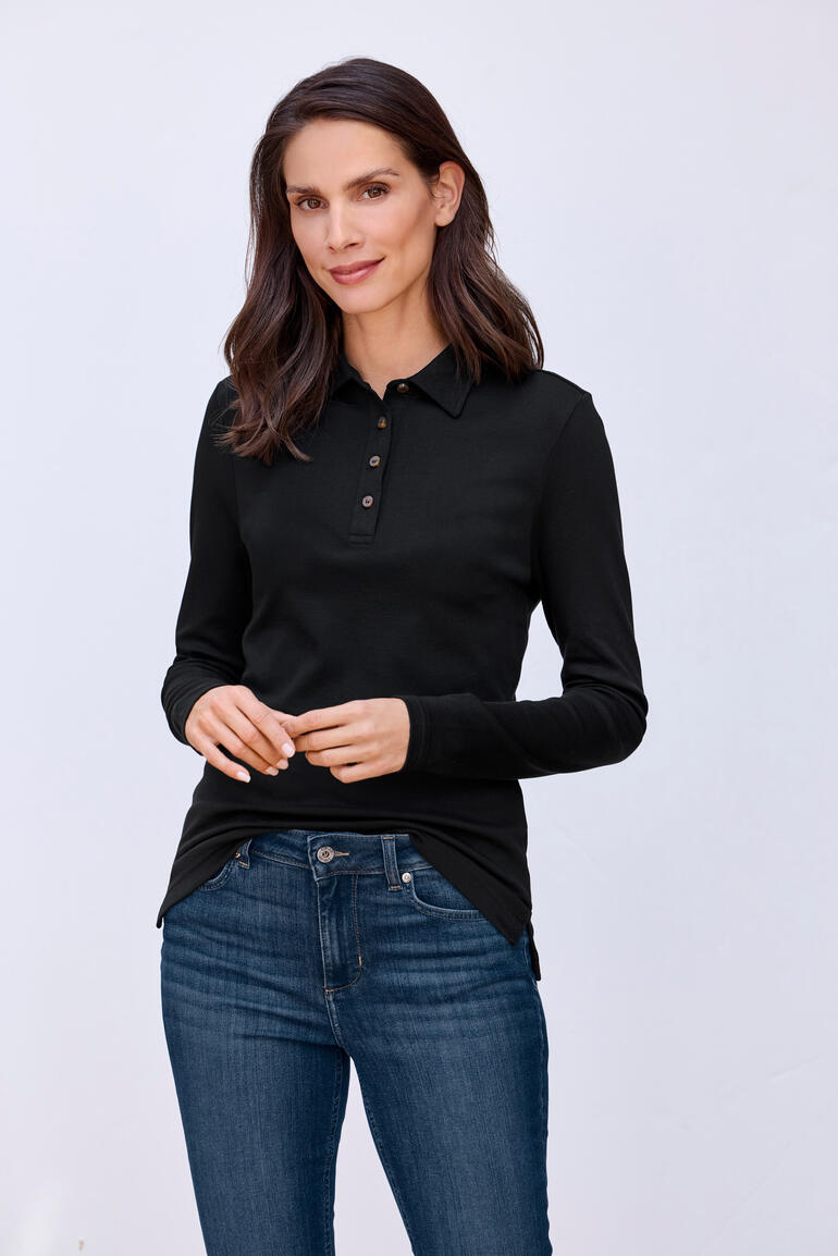 Vrouw in zwart Pima-interlock-polo met knopen.