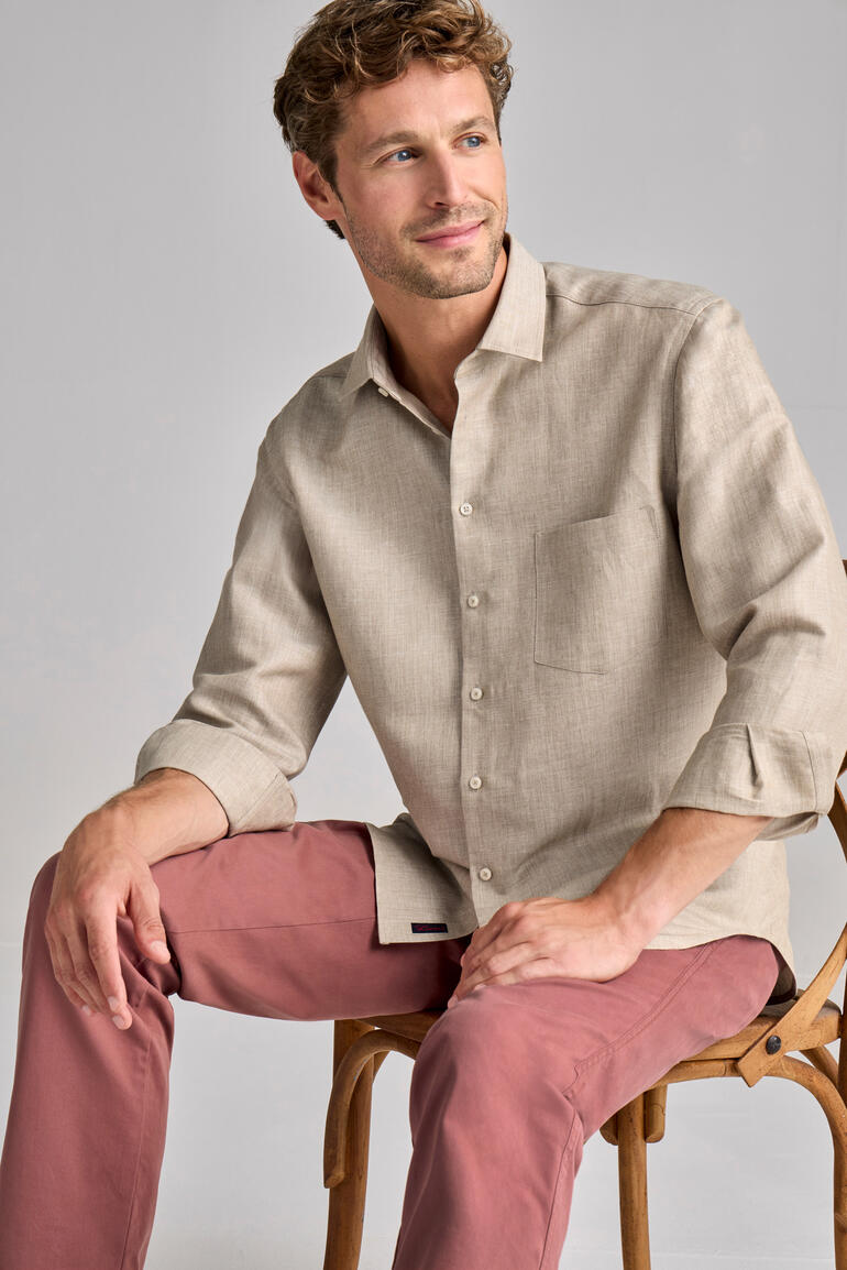 Linnen-merinowol hemd in zandkleur, man zit op een stoel.