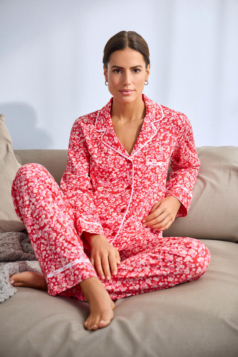 DKNY pyjama met bloemenprint in het rood, model zit op de bank.