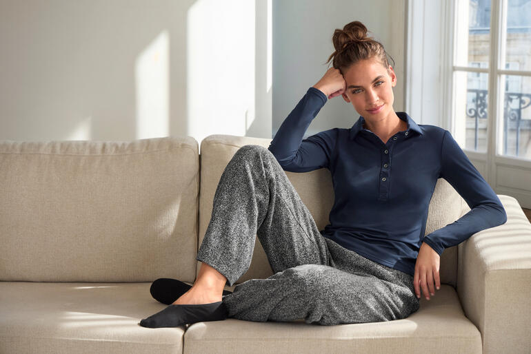 Vrouw in JH1954 alpaca maritiem trui in offwhite op de bank.