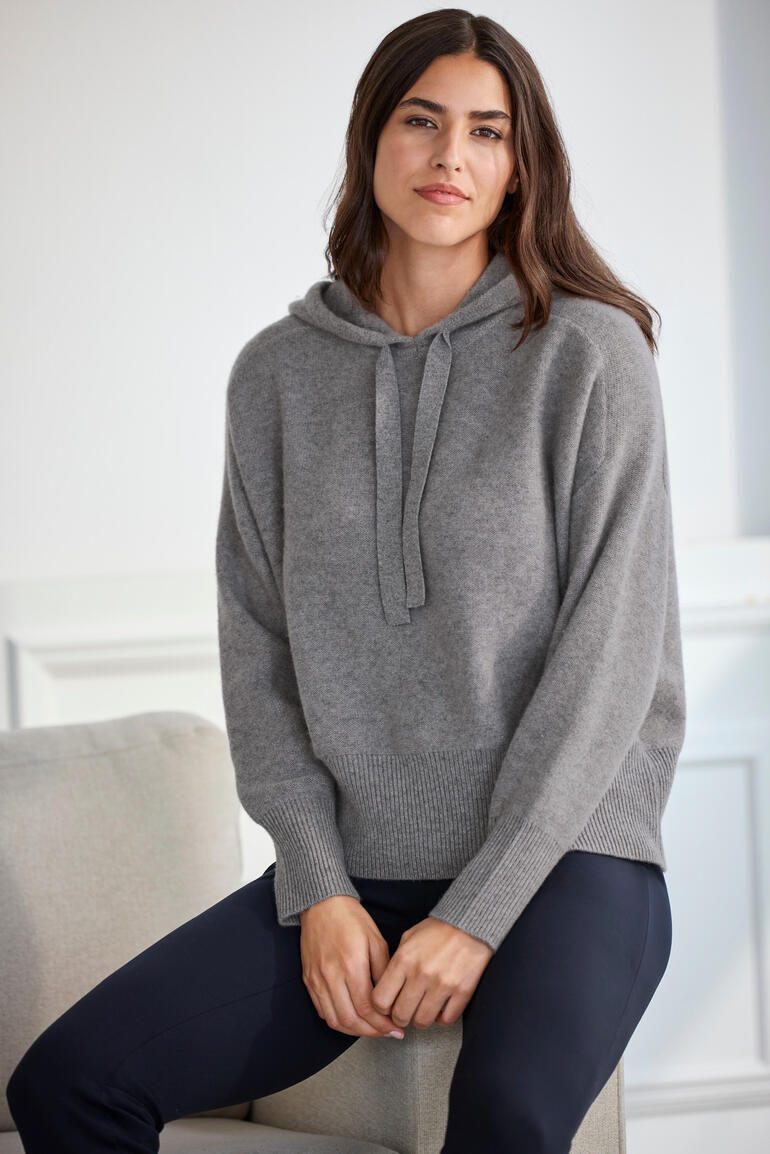 Vrouw zit in grijze Boiled Cashmere D-Hoodie op een stoel