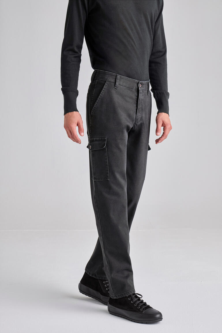 Donkere cargo broek met meerdere zakken, gedragen door een man.