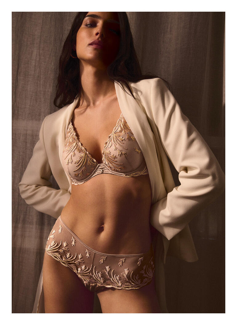 Dames BH met delicate versieringen in zandkleur voor een neutrale achtergrond.